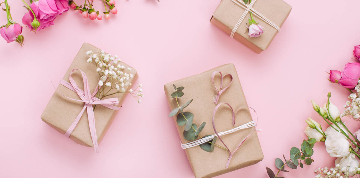 Image of neatly wrapped wedding gifts on a pink table